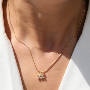 Elegant 18k gold-plated zodiac pendant necklace with micro-pave zircons on a white blazer