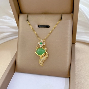 Detailed close-up of a fox pendant with green gemstone and white cubic zirconia accents