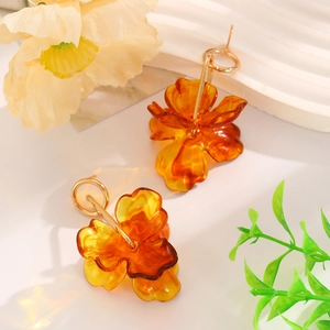 Detail of amber translucent resin flower earrings with gold metallic clips for women