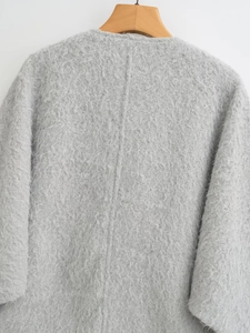 Detailopname van grijze lange mouwen wollen jas met gestructureerde fleece en textuur