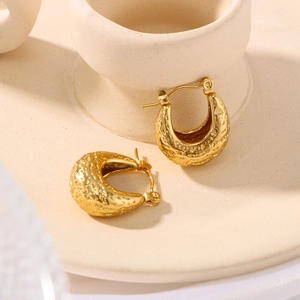 U-shaped textured 18K gold plated titanium steel hoop earrings on a ceramic stand