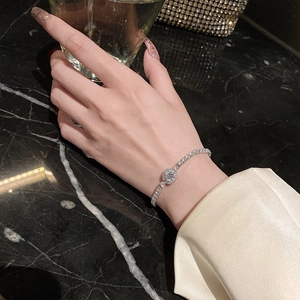 Close-up of elegant adjustable silver bracelet featuring a central round pavé crystal charm
