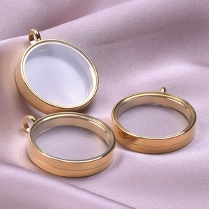 Detail of round gold stainless steel glass locket pendants on pink silk fabric