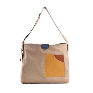 Khaki canvas shoulder bag with brown leather pocket and blue buckle on white background