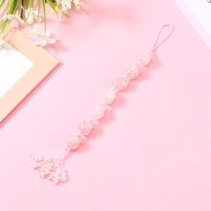 Detail of handmade pink crystal hanging ornament with woven mesh and stone tassels