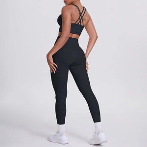 Détail de la brassière de sport à bretelles croisées et du legging de yoga noir sur modèle