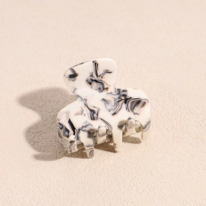 Macro detail of high-quality acetate hair claw clip with elegant black and white marble pattern