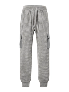 Detail of dark gray waffle texture sweatpants with cargo pockets and drawstring waist