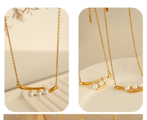 Vue détaillée du collier doré avec trois perles blanches sur un pendentif minimaliste