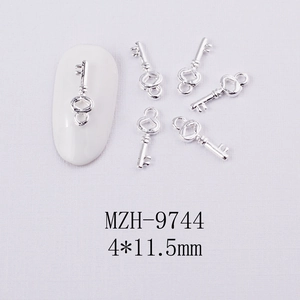 Gros plan de breloques à ongles en alliage argenté en forme de clé de 4x11,5 mm