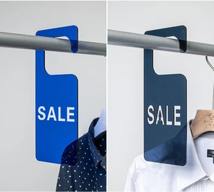 Dos etiquetas SALE de acrílico azul con ganchos para percheros en tiendas de ropa
