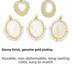 Macro shot of 18K gold plated pendants with white shell religious motifs and tiny pearls