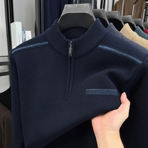 Detailed knit texture and fabric elasticity of a men's navy half-zip sweater