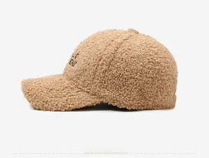Side view of beige teddy fleece baseball cap showing textured plush fabric and embroidery