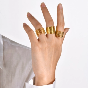 Minimalist gold multi-layer coil stainless steel ring shown on finger in studio lighting