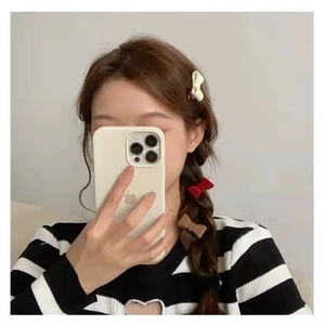 Three-piece velvet bow hair clips in cream, burgundy, and brown worn by a model