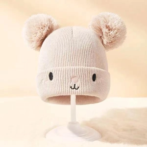 Rosafarbene Strickmütze für Babys mit zwei Bommeln und süßem Bärengesicht für den Winter