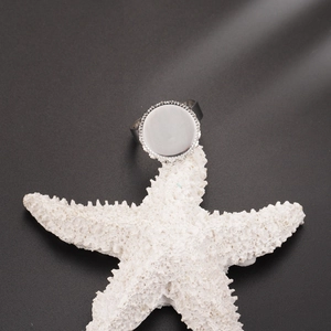 Macro view of adjustable stainless steel ring base with round beaded blank setting on starfish