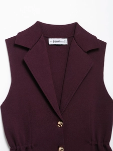 Detail of dark purple knit vest showing lapel collar and golden metal buttons close-up