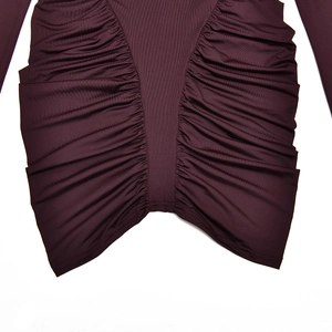 Close-up detail of dark purple ruched fabric with ribbed texture on a long sleeve dress
