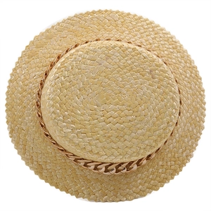 Vue détaillée du chapeau de paille plat avec chaîne dorée et bords à bords dentelés