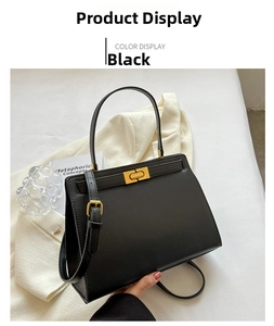 Detail of black crossbody bag with gold lock and matte texture on a beige background