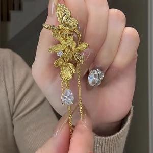 Macro detail of golden butterfly flower tassel earrings with shimmering crystals