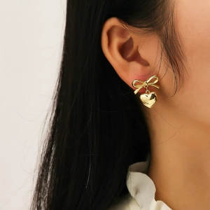 Chic gold-plated titanium bow and heart drop earrings on a model with a polished finish