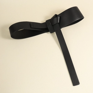 Detail view of black PU leather belt featuring a minimalist knot design for dresses