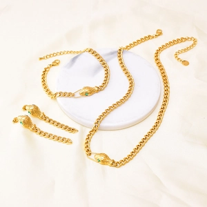 Golden snake-shaped jewelry set with green gemstones including necklace, bracelet, and earrings