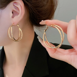 Detail von minimalistischen zweilagigen goldenen Creolen am Modell mit Hochglanz-Finish