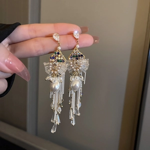 Elegant gold drop earrings with white pearls and long metal tassels in bohemian style