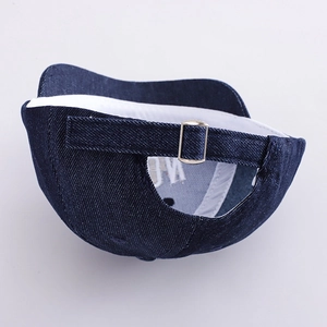 Detail of adjustable metal buckle and dark blue denim texture on the baby baseball cap