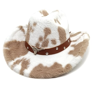 Detail of cow print western hat with silver bull head emblem and studded leather band