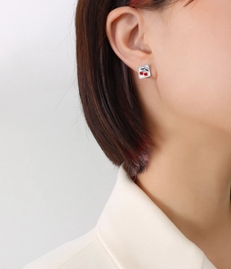Gros plan sur les boucles d'oreilles carrées en titane doré 18 carats avec cerises