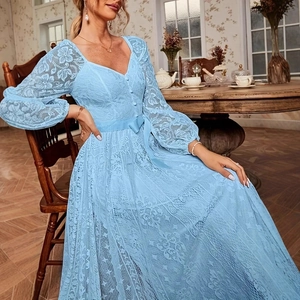 Détail de la robe longue en dentelle bleu clair avec col en V et motif floral