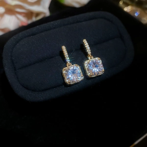 Macro shot of 18k gold plated square halo earrings with zircon in a black velvet box