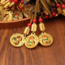 Detail of vintage brass bamboo pen with red bead and lucky gourd pendant charm
