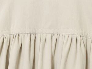 Detailansicht der beigen Raffung und der hochwertigen Twill-Stoffstruktur für Damenjacken