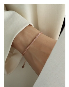 Close-up of a delicate rose gold starry chain bracelet worn on a female wrist