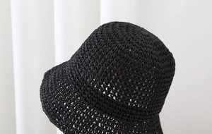Detailed close-up showing the fine texture and weaving of the black straw sun hat