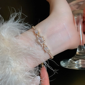 Luxurious adjustable gold bracelet with emerald-cut zircon worn in a party setting