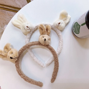 Close-up of cute plush bunny head headbands in cream white and brown lamb wool
