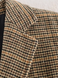 Detailaufnahme des braunen Hahnentritt-Blazer-Revers mit Tweed-Stoffstruktur
