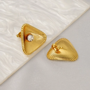 Macro shot of gold vintage triangle stud earrings with sunburst texture and center zircon