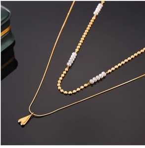 Vue détaillée d'un collier double rang doré avec perles d'eau douce et pendentif cœur