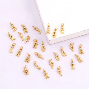 Detailed macro of gold plated copper letter charms with white cubic zirconia inlay