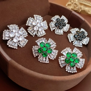 Macro detail of floral stud earrings with sparkling crystals in a velvet jewelry box
