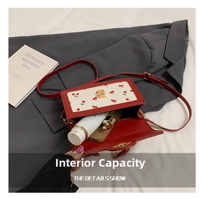 Detail view of red square handbag interior showing capacity for makeup and phone