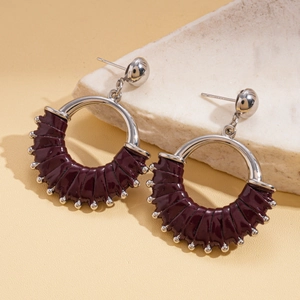 Detailed shot of retro round leather earrings with silver pins and beaded metal trim